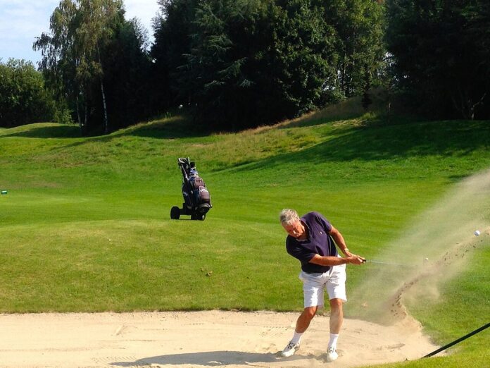 golf-bunker-wedge Golfer playing a bunker shot with a sand wedge